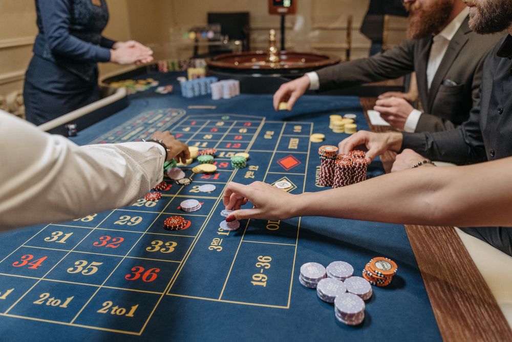 Tangan pemain menempatkan chip kasino di atas meja roulette saat memulai permainan pertama