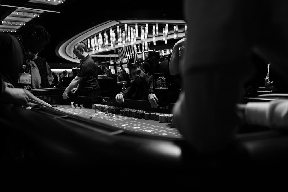 Dadu dadu dilempar di atas meja permainan craps berwarna hitam putih